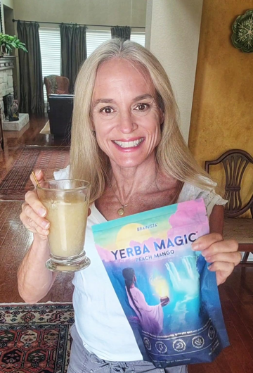 Woman holding a glass of Yerba Magic drink and the product pouch